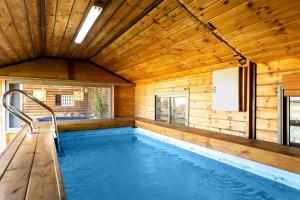 ‘IsfiyāElmanzool Carmel Lodging的木制房屋内的游泳池,设有木制天花板