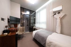 首尔Hotel DM的配有一张床、一张书桌和一扇窗户的酒店客房