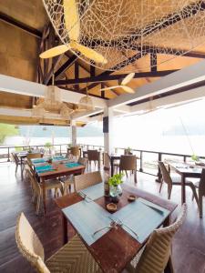 爱妮岛卡德捞度假酒店及餐厅的用餐室配有木桌和椅子