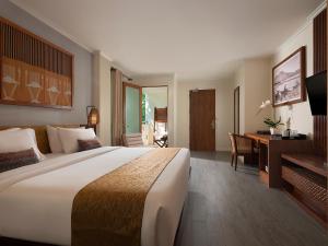 勒吉安Anantara Vacation Club Legian的酒店客房设有一张大床和一张书桌。