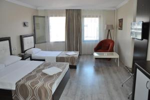 KonakKonak EuroBest Otel的酒店客房,配有两张床和椅子