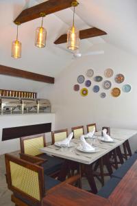 达拉万度Athirige Private Villa的墙上的饭厅配有桌椅和盘子