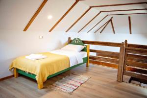 ŞinteuDue Fratelli Village Resort的卧室配有一张床铺,位于带横梁的房间内