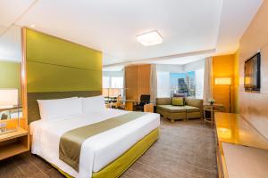 曼谷Holiday Inn Bangkok Silom, an IHG Hotel的配有一张床和一张书桌的酒店客房