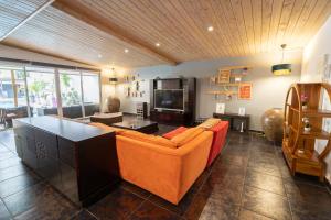 圣皮埃尔Villa LAtibulum的客厅配有橙色沙发和电视