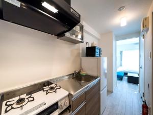 名户Hotel Tomas Nago的厨房配有炉灶、水槽和冰箱。