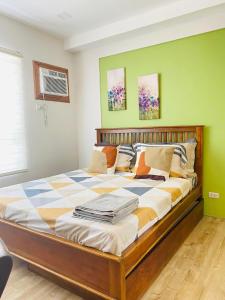 Bantud HaciendaMesavirre Garden Residences的一张大床,位于带绿色墙壁的房间