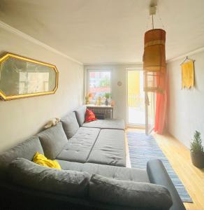 慕尼黑Helle, grosse, zentrale Wohnung mit Balkon的客厅配有灰色的沙发和镜子
