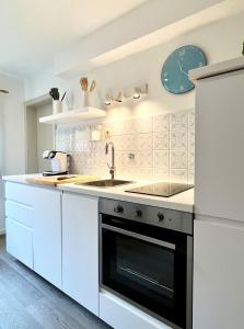 克罗伊特Ferienhaus Anni的白色的厨房配有水槽和冰箱
