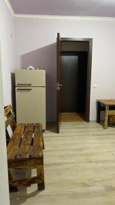 塞凡Sevan cottage的客房设有冰箱和木制长凳。