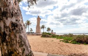韦尔瓦LUZ DE PATIOS的海滩上的一座纪念碑,背后是棕榈树
