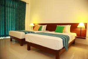 卡特勒格默桑维尔旅游度假村的配有绿窗帘的酒店客房的两张床