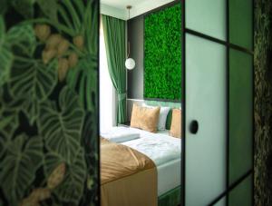 斯维诺乌伊希切Aparthotel Green Concrete - nowy, ekologiczny hotel w Świnoujściu的一间卧室配有一张带绿色墙壁的床