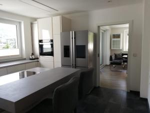 斯皮茨Ferienhaus Johanna的厨房配有桌子和不锈钢冰箱。