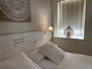 科尔多瓦Aljara Mezquita的卧室配有白色的床和窗户。