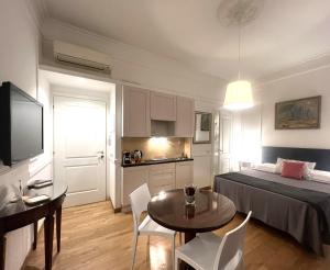 罗马INTERNO ROMA的一间卧室配有一张床铺和一张桌子,还设有一间厨房