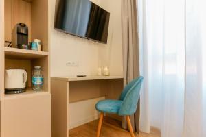 卡利亚里Aqua Comfort Rooms - Eja Sardinia的一间设有蓝色椅子和电视的房间