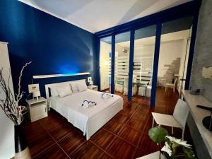 焦维纳佐Casadamare Holiday Home的卧室配有白色的床和蓝色的墙壁
