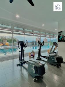 怡保Ipoh D Festivo Suites 6-10pax 10mins to Sunway Tambun by IWH的一个带两个跑步机和一个游泳池的健身房