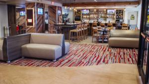 亚特兰大Holiday Inn Hotel Atlanta-Northlake, a Full Service Hotel的一间带两把椅子的餐厅和一间酒吧