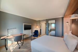 尼斯NH尼斯酒店的配有一张床和一张书桌的酒店客房