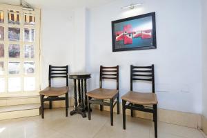 加尔各答Hotel Homely Raj Near Kalighat Kali Temple的一套椅子和一张桌子