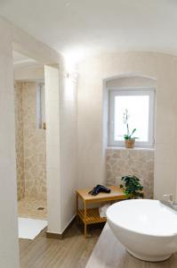 巴里Modern Stone Apartment in the Heart of Bari的一间带大浴缸和窗户的浴室