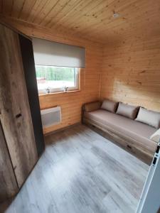 LeśnoOsada Rolbik的小木屋内的小房间,配有沙发