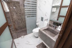 利雅德Luxury Night Hotel的一间带水槽、淋浴和卫生间的浴室