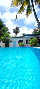 瓦都瓦Calm Villa Wadduwa的一座大蓝色游泳池,位于房子前