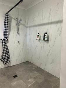 ClermontClermont Guest House - Pet friendly的一间设有白色大理石墙壁和淋浴的浴室