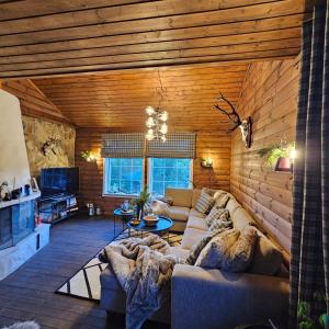 KvamBjørnebu- Ski in-ski out的一间客厅,客厅配有沙发,位于木房