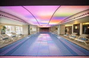 贝莱克卡亚贝莱克酒店的一个带椅子和彩虹天花板的游泳池