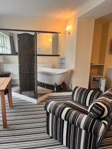 布莱克浦The Oxfordshire的一间带浴缸和沙发的客厅