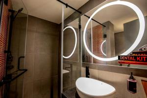 苏拉特金吉尔苏拉特酒店的一间带卫生间和圆镜子的浴室