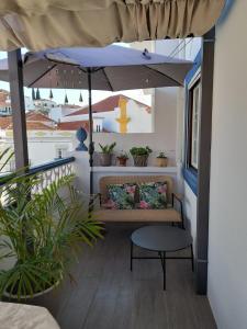 萨尔堡Cantinho do Céu的一个带长凳和遮阳伞的门廊