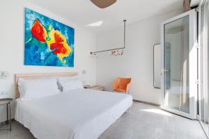 新福卡THE VIEW B&B, terrace & more的卧室配有白色的床和墙上的绘画作品