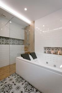 Biskupice七棵树度假村的带淋浴的浴室配有白色浴缸。