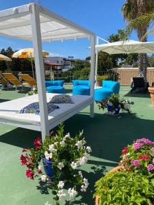 伊斯基亚Hotel Parco Delle Agavi的鲜花和遮阳伞庭院内的一张床铺