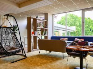 克雷泰伊诺富特巴黎克里特尔湖滨酒店的带沙发、椅子和桌子的客房