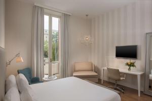 热那亚热那亚中心NH酒店的酒店客房配有一张床、一张书桌和一台电视。