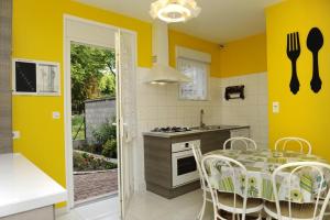 Méry-sur-SeineLe claujovin的厨房设有黄色的墙壁和桌椅