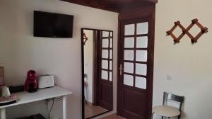罗萨里奥港Mi habitación de invitados的一间设有镜子和墙上电视的房间
