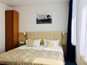 莱比锡爱木贝瑞斯臣广场酒店的卧室配有一张带白色床单和枕头的大床。