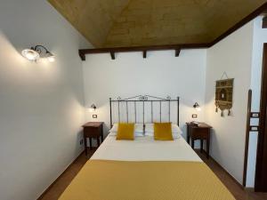 圣维托罗卡波Ai Dammusi Rooms的一间卧室配有一张带两个黄色枕头的床