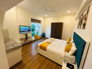 古尔冈Amahi Inn的一间卧室配有一张床、一张书桌和一台电视
