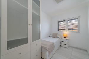 普拉亚布兰卡Apartamento 1 linea centro Playa Blanca的白色的卧室设有床和窗户