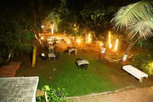 KīhīmVisava Cottages Kihim Beach的享有花园的顶部景色,晚上配有桌椅