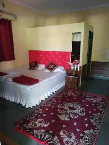 KīhīmVisava Cottages Kihim Beach的一间卧室配有一张红色床头板和红色地毯的床