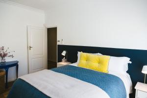 塞雷斯Cherry Blossom - Backup Power Inverter的卧室配有蓝色和白色的床以及黄色枕头